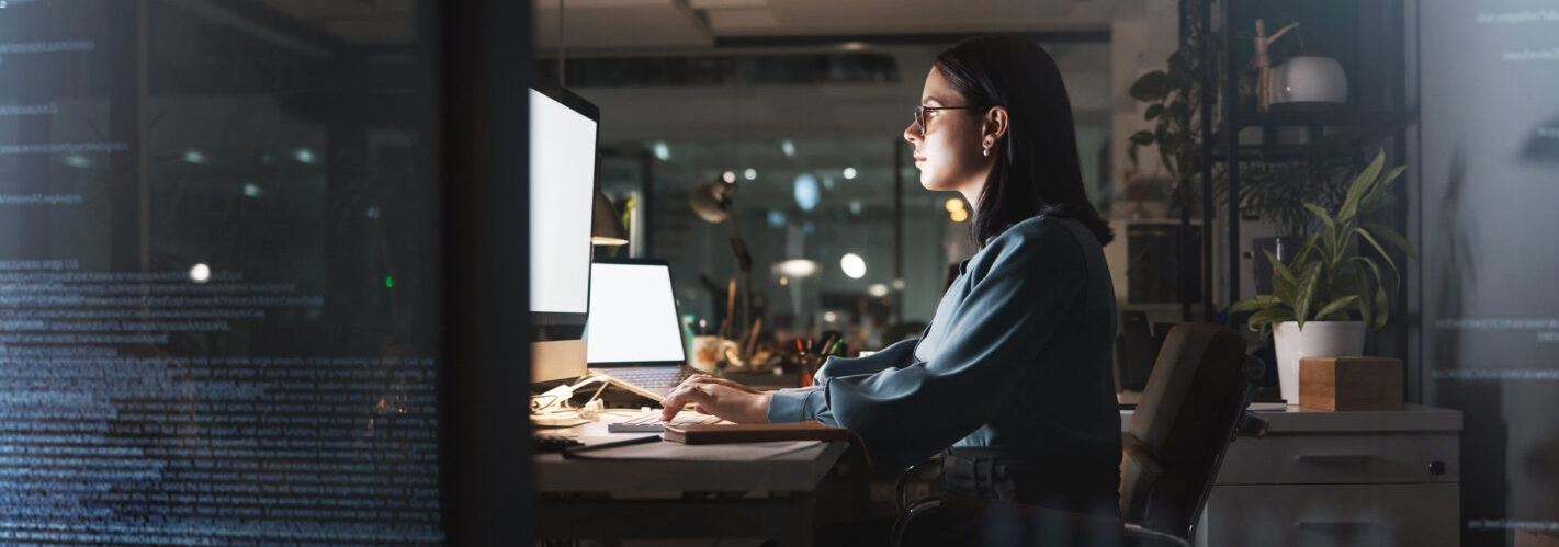 Office woman and night coding with futuristic overlay for cyber security, programming and work. Programmer, code and overtime employee working with mockup computer and laptop screen at desk.